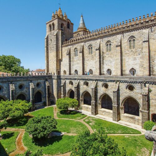 Chiostro medievale con giardino fiorito e cattedrale gotica. agenzia viaggio torino