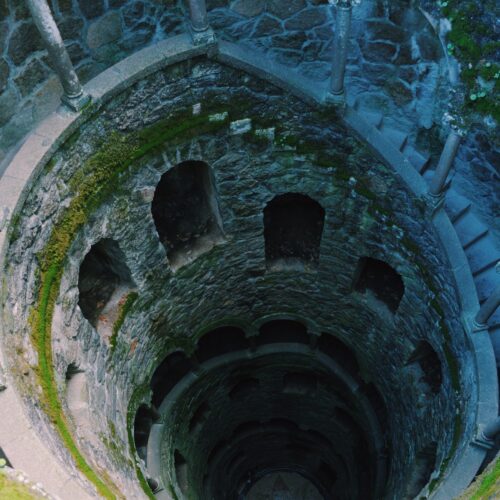 Antica scala a chiocciola in pietra coperta di muschio verde. migliore agenzia viaggi torino