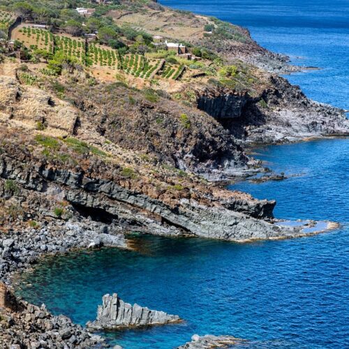 costa sul mare con una leggera vegetazione raggiungibile con dei viaggi di gruppo da Torino