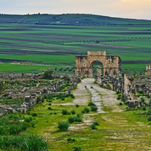 vista su praterie con diverse costruzioni antiche comodamente raggiungibile con viaggi in bus da Cuneo